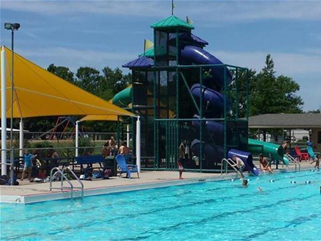 A large swimming pool featuring a slide and a water slide